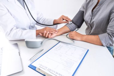 Doktor steteskop kullanarak arteryel kan basıncını ölçüyor.