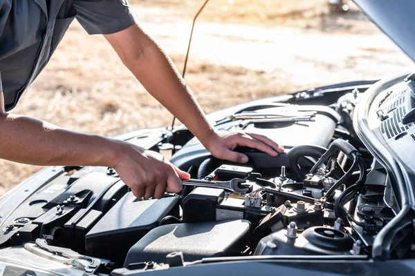 Technician hands of car mechanic in doing auto repair service an