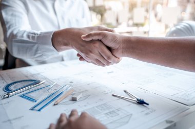 Team of architects or engineering shaking hands while working co