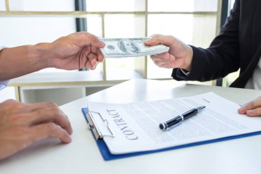 İş adamı, ortağının zarfında rüşvet veriyor. 