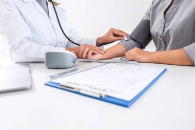 Doktor steteskop kullanarak arteryel kan basıncını ölçüyor.