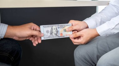 İşadamı kendi payını vermesi için masa altından rüşvet veriyor.
