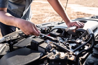 Otomobil tamircisinin teknisyen elleri ve bakım işçisi İngiliz anahtarı, servis ve bakım araba kontrolü ile aracı tamir ediyor..