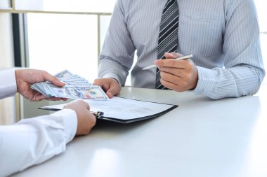 Yasadışı, sahtekâr, rüşvet ve yolsuzluk konsepti. İş adamı, yolsuzluk sahtekarlığında anlaşma anlaşmasını başarılı kılmak için ortağına rüşvet veriyor..