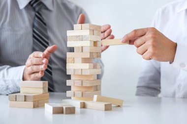 Ticarette Risk ve Strateji Planlama, iki iş adamının el ele verip tahta blok yapısını kulede büyütmesi ve planlama ve geliştirmenin başarıya ulaşması.