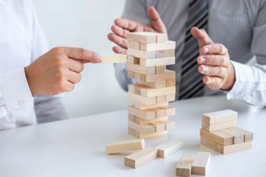 Ticarette Risk ve Strateji Planlama, iki iş adamının el ele verip tahta blok yapısını kulede büyütmesi ve planlama ve geliştirmenin başarıya ulaşması.