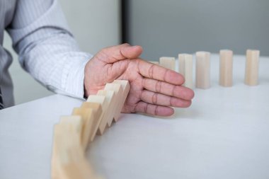 Ticarette Risk ve Strateji Planlama, el işadamı görüntüsü, tahta blok oyununun çöküşü için durdurma ve koruma, domino taşları sorunu çözme sorunu.