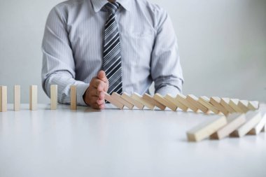 Ticarette Risk ve Strateji Planlama, el işadamı görüntüsü, tahta blok oyununun çöküşü için durdurma ve koruma, domino taşları sorunu çözme sorunu.