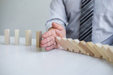 Ticarette Risk ve Strateji Planlama, el işadamı görüntüsü, tahta blok oyununun çöküşü için durdurma ve koruma, domino taşları sorunu çözme sorunu.