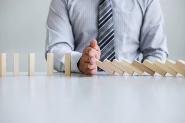 Ticarette Risk ve Strateji Planlama, el işadamı görüntüsü, tahta blok oyununun çöküşü için durdurma ve koruma, domino taşları sorunu çözme sorunu.