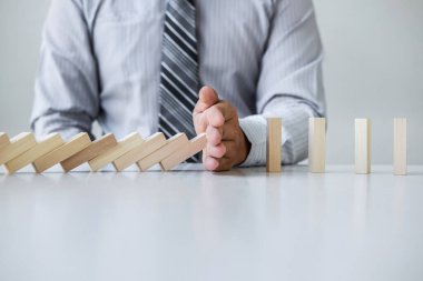 Ticarette Risk ve Strateji Planlama, el işadamı görüntüsü, tahta blok oyununun çöküşü için durdurma ve koruma, domino taşları sorunu çözme sorunu.