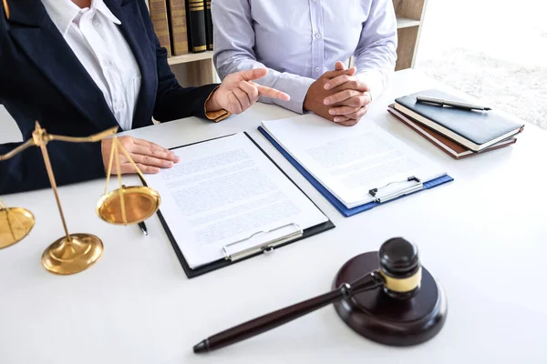 Professional Female lawyer discussing negotiation legal case with client meeting with document contact in courtroom, law and justice concept.