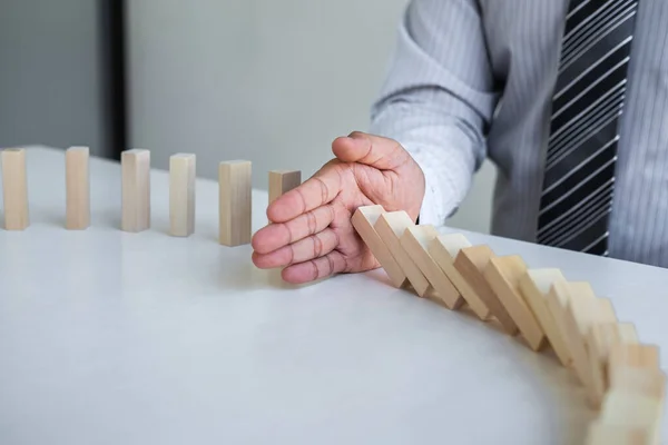 Ticarette Risk ve Strateji Planlama, el işadamı görüntüsü, tahta blok oyununun çöküşü için durdurma ve koruma, domino taşları sorunu çözme sorunu.