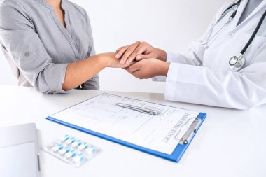 Hastanenin sağlık muayenesi sırasında hastaya dokunan doktorun eli hastaya destek olması ve empati göstermesi için güven veriyor..