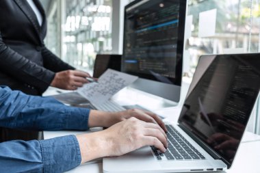 IT şirketinin ofisindeki yazılım geliştirme bilgisayarında proje üzerinde çalışan geliştirici programcı ekibi, problem çözümü bulmak için kodlar ve veri kodu web sitesi ve kodlama veritabanı teknolojileri.