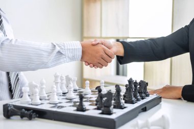 Oyuncu, İşadamı ve İş Kadını ile siyah ve beyaz satranç, rakip oyuncu ve planlama ile rekabetteki satranç figürlerini hareket ettirmek için düşünme stratejisinin ardı ardına el sıkışıyor.