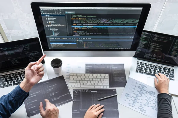 IT şirketinin ofisindeki yazılım geliştirme bilgisayarında proje üzerinde çalışan geliştirici programcı ekibi, problem çözümü bulmak için kodlar ve veri kodu web sitesi ve kodlama veritabanı teknolojileri.