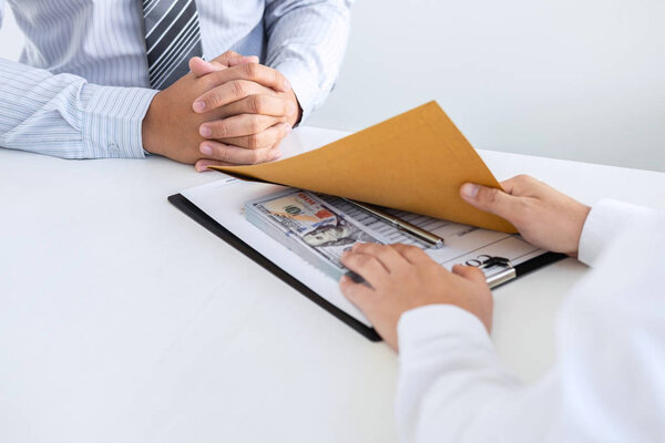 Незаконная, нечестная, взяточничество и коррупция концепция, бизнесмен дает взятку деньги в конверте своего партнера, чтобы дать успех контракт сделки в коррупционной афере для взяточничества
.