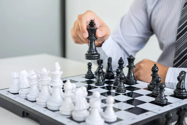 Black and White chess with player, Hands of businessman thinking to moving chess figure in competition and planning strategy to success play for win.