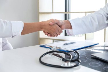 Finishing of consulting, Doctor and patient shaking hands after a good and successful treatment in the hospital, healthcare and assistance concept.