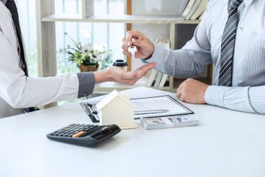 Emlakçı ev kredisi sunuyor ve onaylanmış emlak başvurusu formu, Sigorta Konsepti ile ev satın almak için sözleşme imzaladıktan sonra anahtarlarını müşteriye gönderiyor.