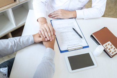 Hastanenin tıbbi muayenesi sırasında hastaya destek olması ve empati göstermesi için dokunan bir doktor eli..