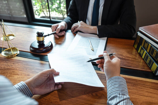 Юрист-мужчина обсуждает переговорный процесс с клиентом о встрече с контактом по документам в зале суда, концепции права и правосудия.