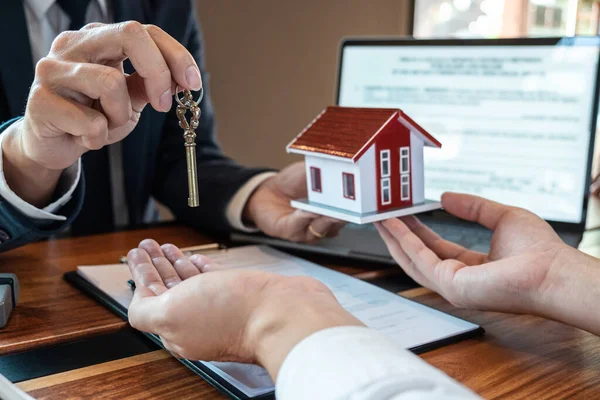 Sale purchase contract to buy a house, Customer sending money buying home loan and giving keys from Agent after signing contract to buy house with approved form, Insurance and Home concept.