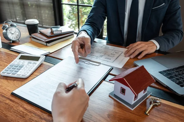 Sale purchase contract to buy a house, Real estate agent are presenting home loan and giving keys to customer after signing contract to buy house with approved property application form.