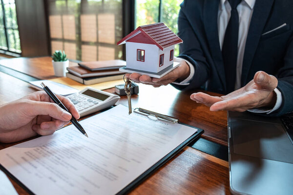 Sale purchase contract to buy a house, Customer sending money buying home loan and giving keys from Agent after signing contract to buy house with approved form, Insurance and Home concept.