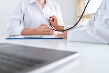 Doktor steteskop kullanarak hastayı hastalık, hastalık durumları ve tedavi yöntemleri hakkında kontrol ediyor..