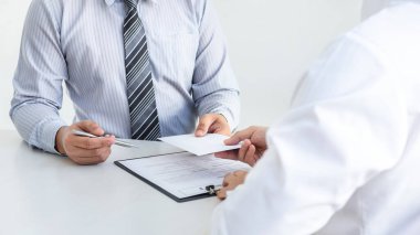 İş adamı, yolsuzluk, yasadışı, sahtekarlık, rüşvet ve yolsuzluk konseptinde anlaşmayı başarıya ulaştırmak için ortaklarının zarfına rüşvet veriyor..