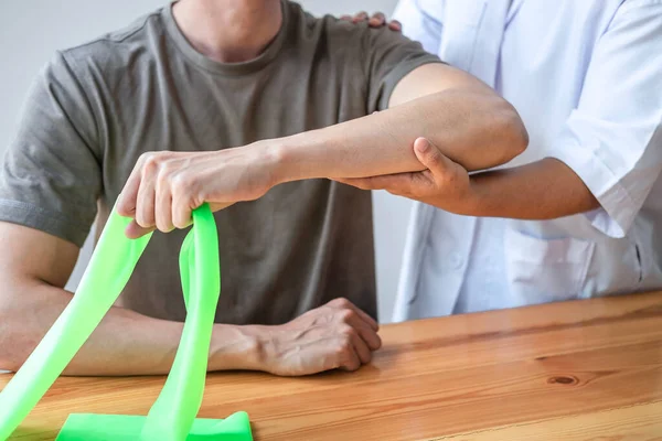 Female Physiotherapist Working Examining Treating Injured Arm Athlete Male Patient — Stock Photo, Image