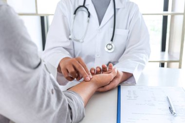 Doktor, hastanın el nabzına uygulanan basıncı kontrol ediyor. Tıbbi ve sağlık hizmetleri kavramı..