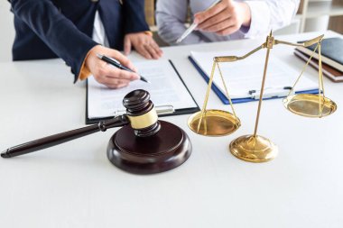Professional Female lawyer discussing negotiation legal case with client meeting with document contact in courtroom, law and justice concept.