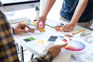 Modern ofiste çalışan grafik tablet ve renk örnekleri üzerine çizim yapan genç İç mimari çalışma evi projesinin takım tasarımı, yaratıcı ilham ve hayal gücü.