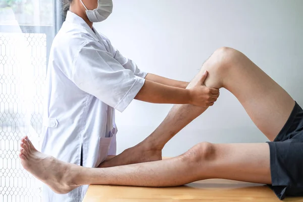 Female Physiotherapist Working Examining Treating Injured Leg Male Patient Doing — Stock Photo, Image