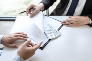 İş adamı, yolsuzluk, yasadışı, sahtekarlık, rüşvet ve yolsuzluk konseptinde anlaşmayı başarıya ulaştırmak için ortaklarının zarfına rüşvet veriyor..