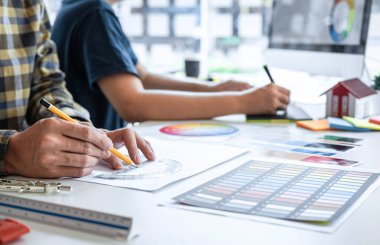 Modern ofiste çalışan grafik tablet ve renk örnekleri üzerine çizim yapan genç İç mimari çalışma evi projesinin takım tasarımı, yaratıcı ilham ve hayal gücü.