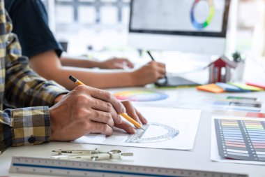 Modern ofiste çalışan grafik tablet ve renk örnekleri üzerine çizim yapan genç İç mimari çalışma evi projesinin takım tasarımı, yaratıcı ilham ve hayal gücü.