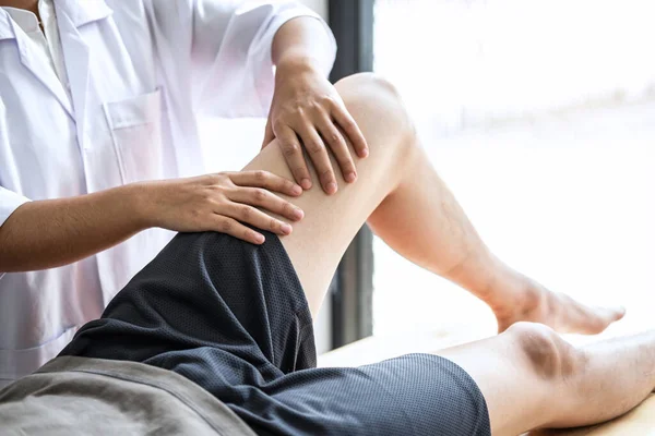女性理学療法士男性患者の足の負傷者の治療を検討作業 クリニックでのリハビリテーション療法の痛みを行います — ストック写真