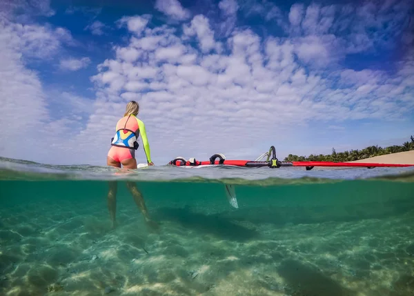 beautiful slim windsurfer girl, view from the water cut