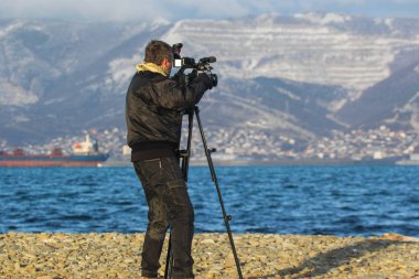 Kış plajında video operatörü.