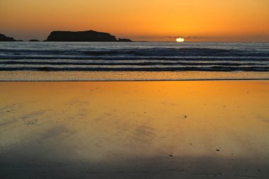 Gün batımında sular çekildiğinde ıslak kum.