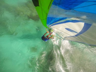 Selfie photo of windsurfing riding on colored sail clipart