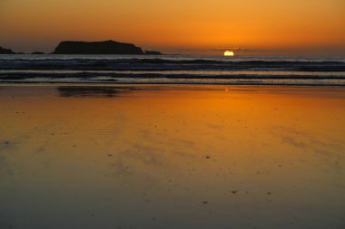 Gün batımında sular çekildiğinde ıslak kum.