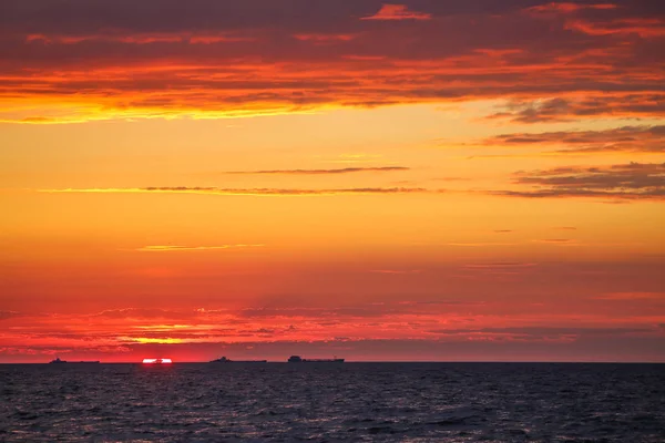 Barcos mercantes en el horizonte en el fondo de un fuego — Foto de Stock