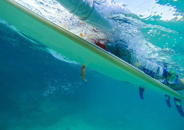 Chica en una tabla de surf en una ola oceánica bajo el agua — Foto de Stock