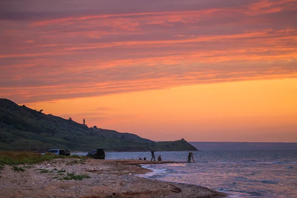 Pescadores na praia ao pôr do sol — Fotografia de Stock