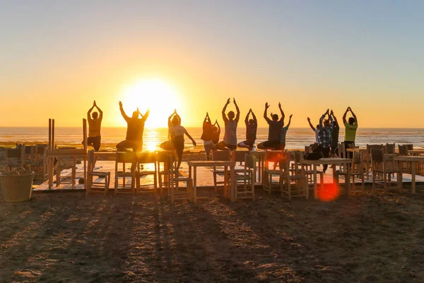 Gün batımında grup yogası.